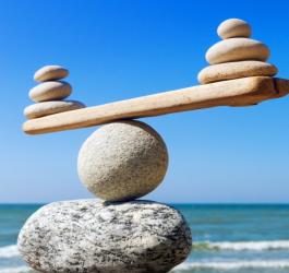 Kamienie na plaży, ułożone na sobie tak, aby utrzymywały idealny balans.